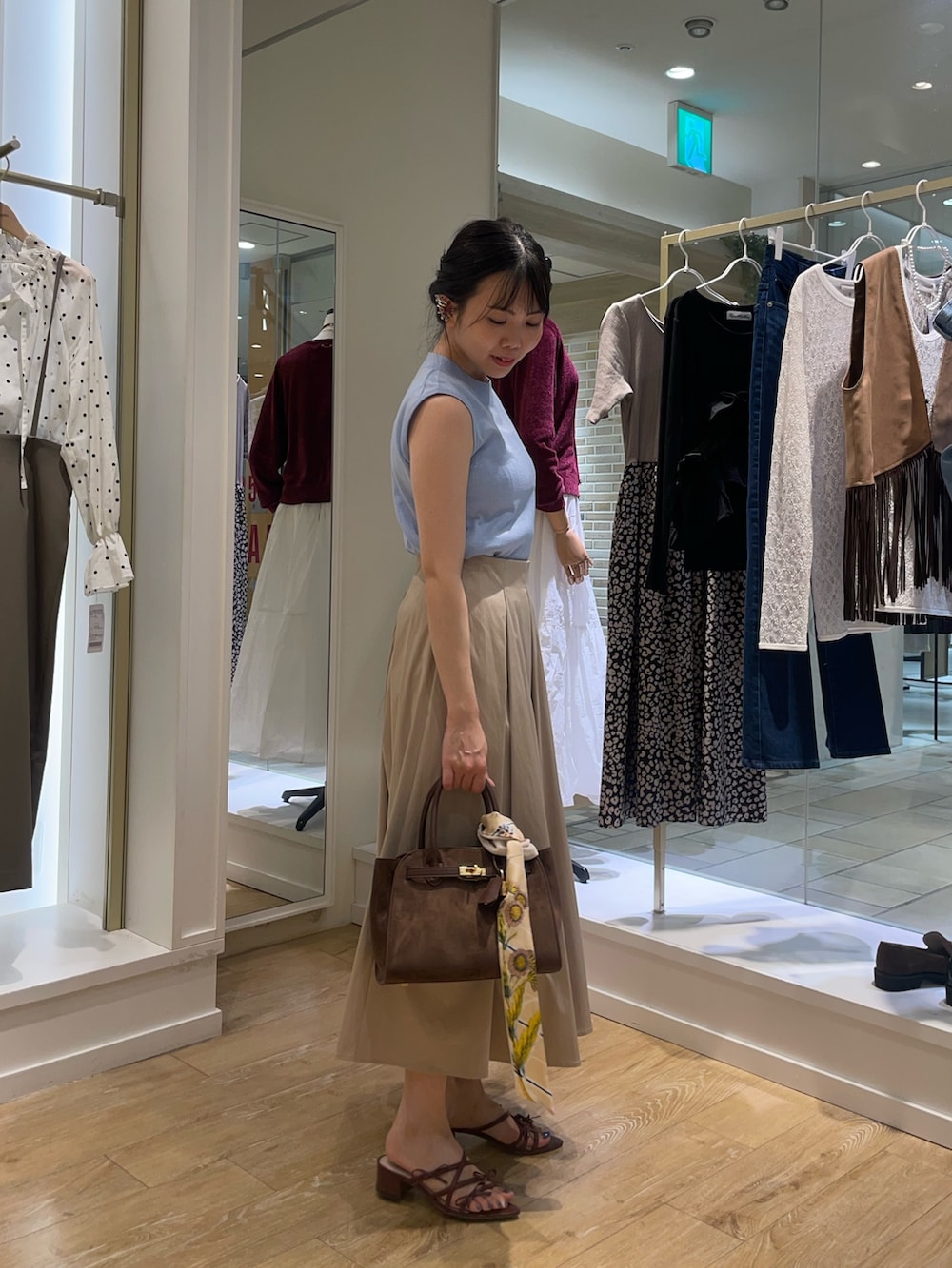 ブルー系のニット/セーター、ベージュ系のスカートを着用したレディースの秋コーディネートの6枚目の写真