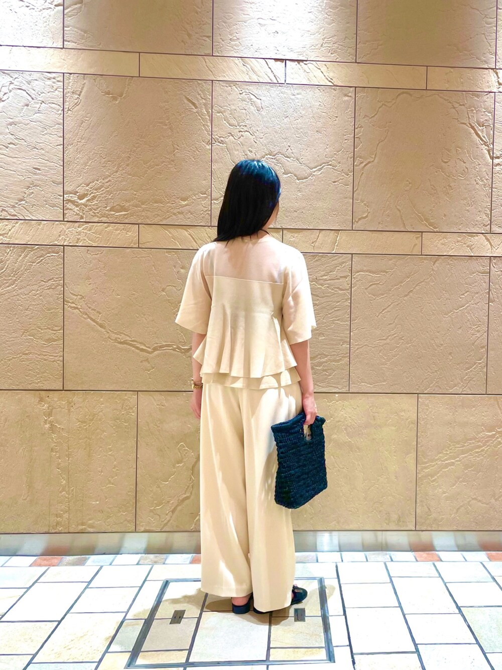 ベージュ系のニット/セーター、ホワイト系のその他パンツ、ブラック系のかごバッグを着用したレディースの夏コーディネートの3枚目の写真