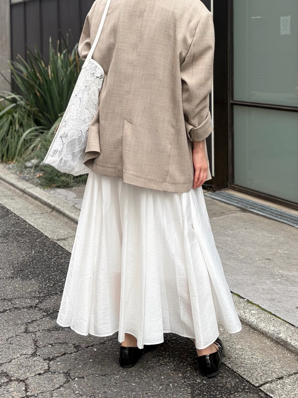 ブルー系のシャツ/ブラウス、ホワイト系のスカート、ベージュ系のテーラードジャケットを着用したレディースの春コーディネートの9枚目の写真