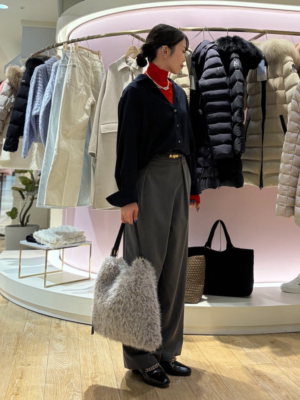 レッド系のニット/セーター、ホワイト系のシャツ/ブラウス、ベージュ系のショルダーバッグを着用したレディースの冬コーディネートの4枚目の写真