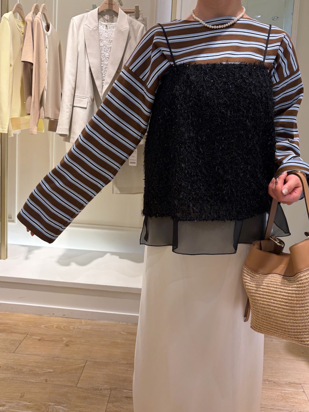 ベージュ系のTシャツ/カットソー、ブラック系のシャツ/ブラウス、ホワイト系のスカートを着用したレディースの春コーディネートの9枚目の写真