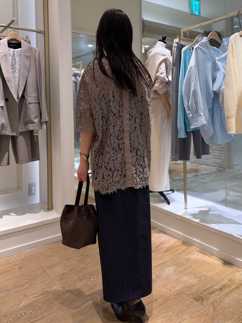 ブルー系のスカート、ブラウン系のショルダーバッグ、その他のネックレスを着用したレディースの冬コーディネートの4枚目の写真