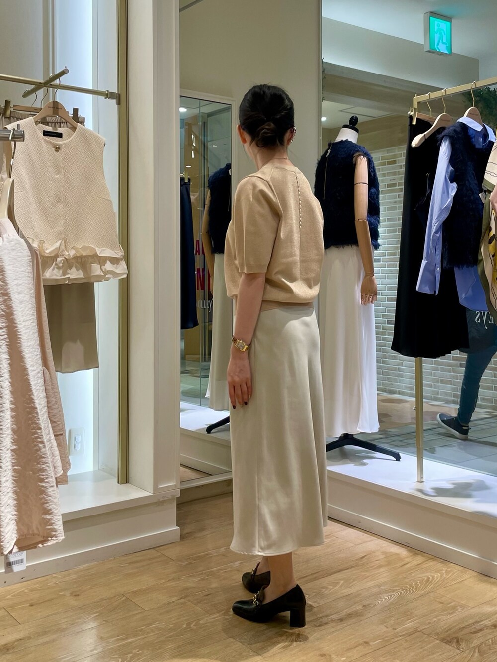 イエロー系のニット/セーター、ベージュ系のスカートを着用したレディースの秋コーディネートの4枚目の写真