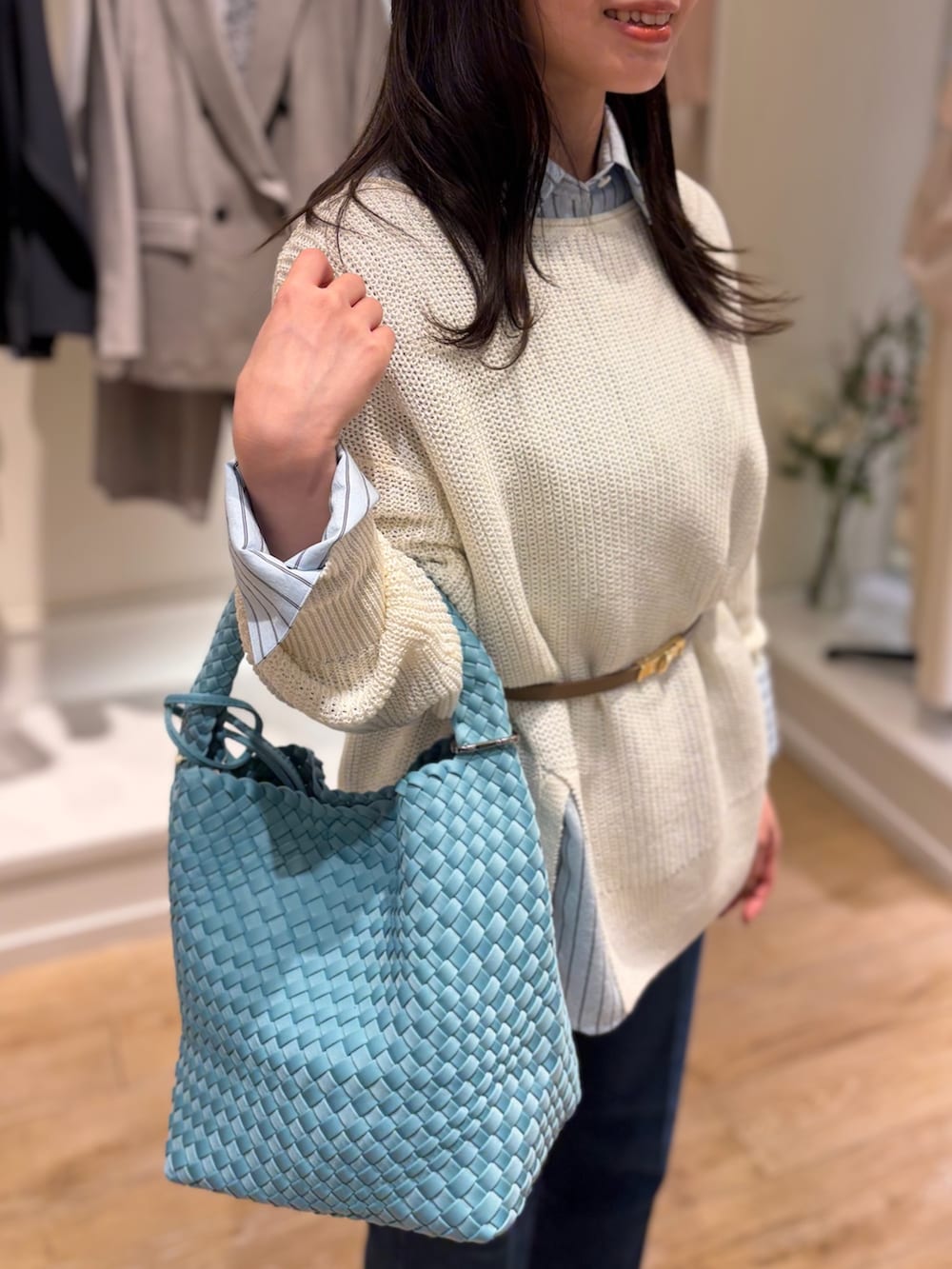 ベージュ系のステンカラーコート、ブルー系のシャツ/ブラウス、ホワイト系のニット/セーターを着用したレディースの冬コーディネートの8枚目の写真