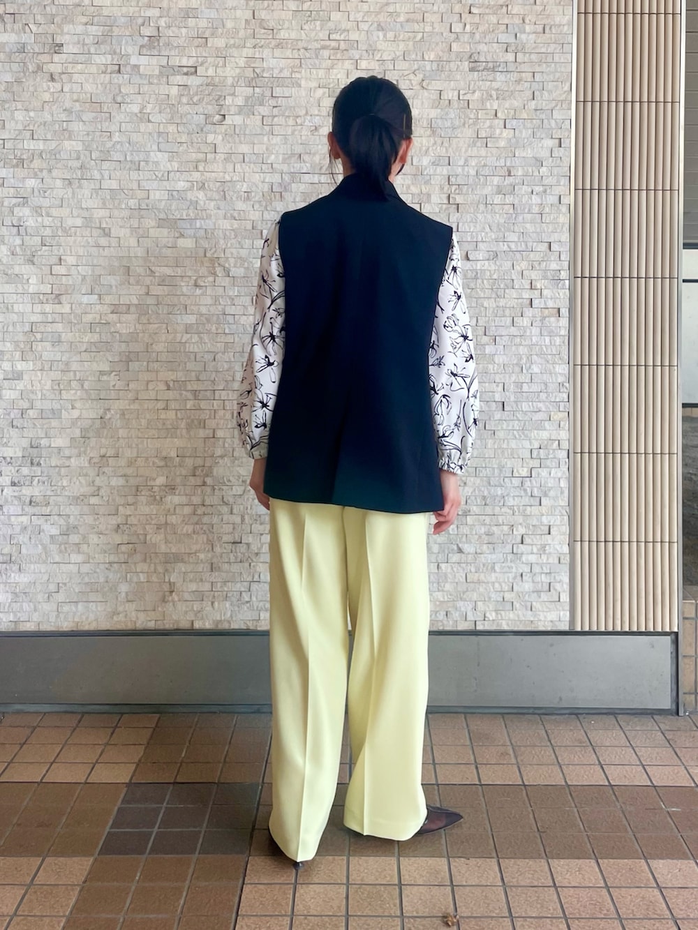 ブラック系のベスト、ホワイト系のシャツ/ブラウス、イエロー系のその他パンツを着用したレディースの春コーディネートの3枚目の写真