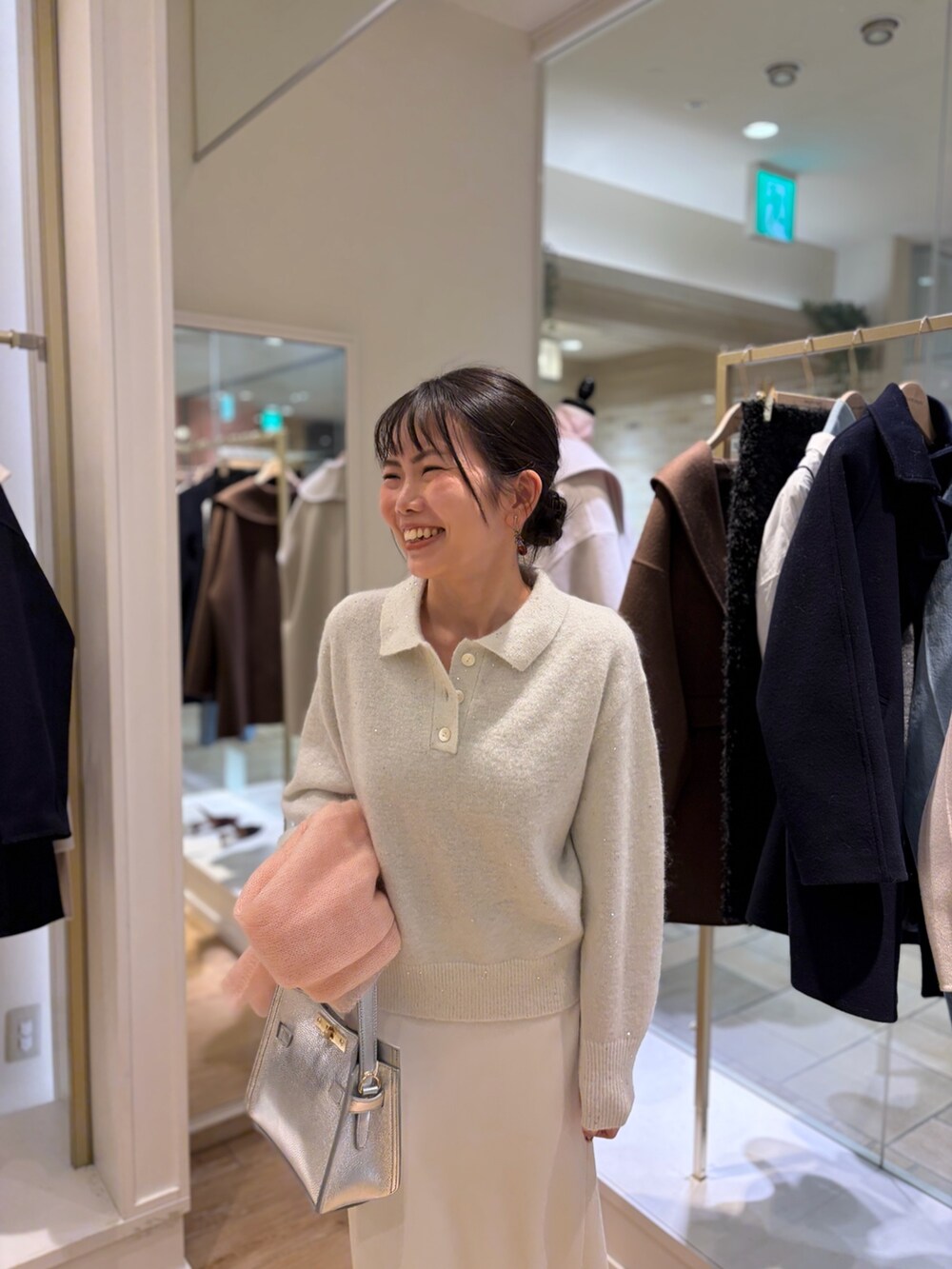 ホワイト系のニット/セーター、シルバー系のショルダーバッグ、ホワイト系のスカートを着用したレディースの秋コーディネートの4枚目の写真