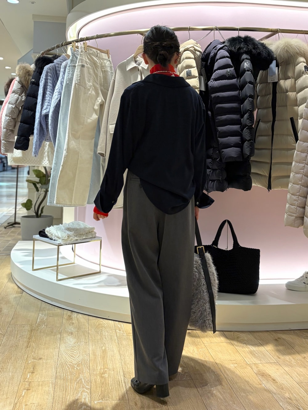 レッド系のニット/セーター、ホワイト系のシャツ/ブラウス、ベージュ系のショルダーバッグを着用したレディースの冬コーディネートの3枚目の写真