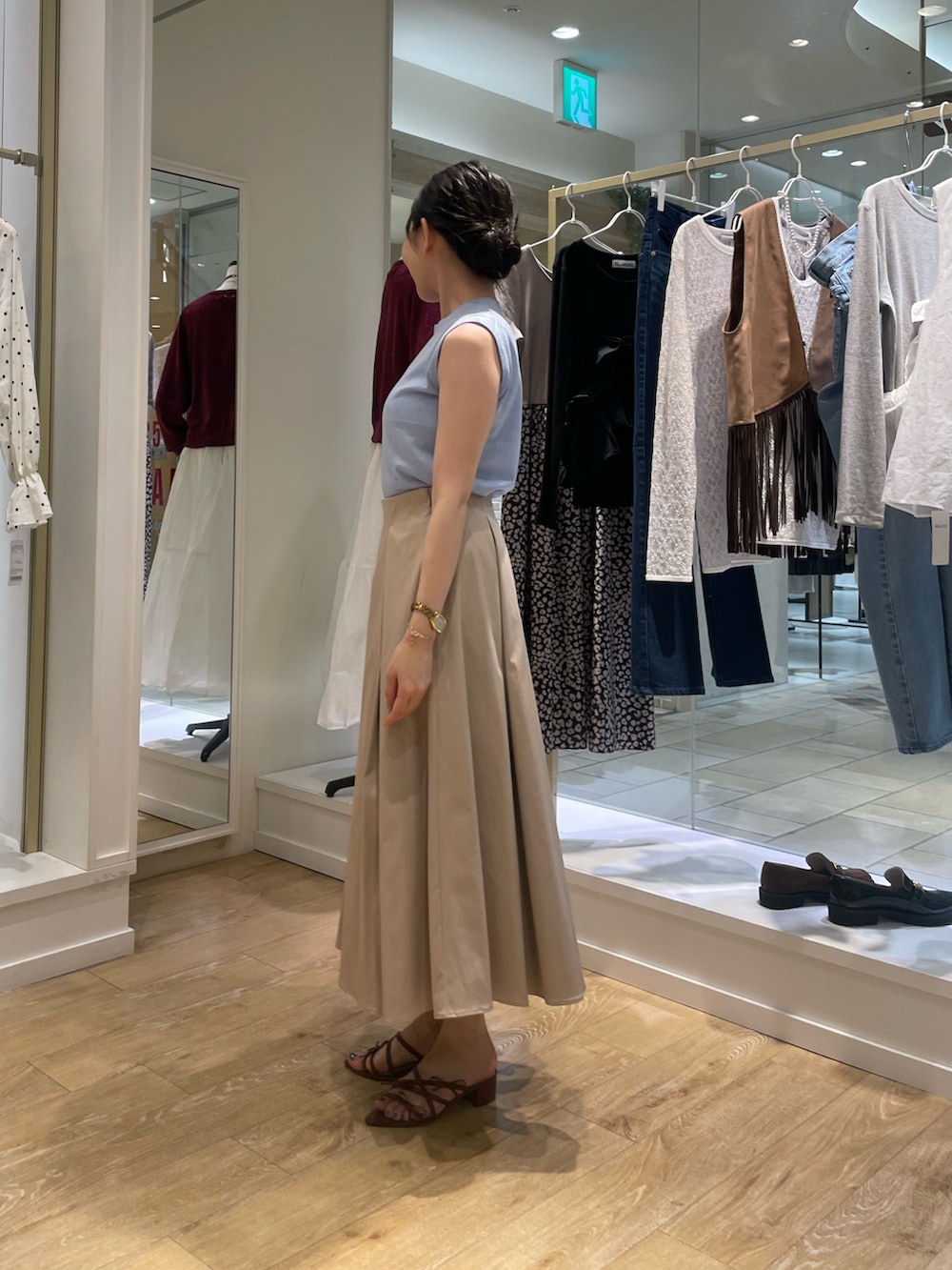 ブルー系のニット/セーター、ベージュ系のスカートを着用したレディースの秋コーディネートの3枚目の写真