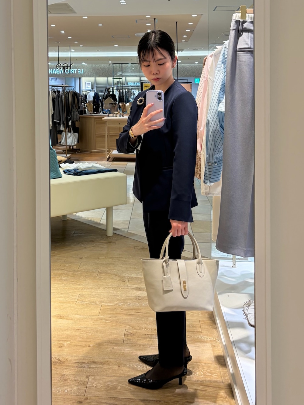 ホワイト系のシャツ/ブラウス、ブルー系のノーカラージャケット、ベージュ系のトートバッグを着用したレディースの春コーディネートの3枚目の写真