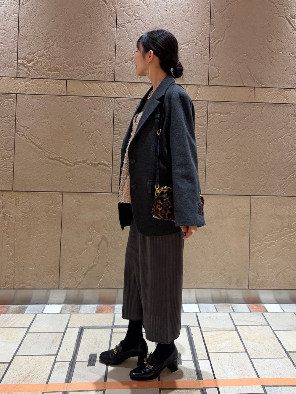 グレー系のテーラードジャケット、その他のボストンバッグ、ベージュ系のキャミソールを着用したレディースの冬コーディネートの2枚目の写真