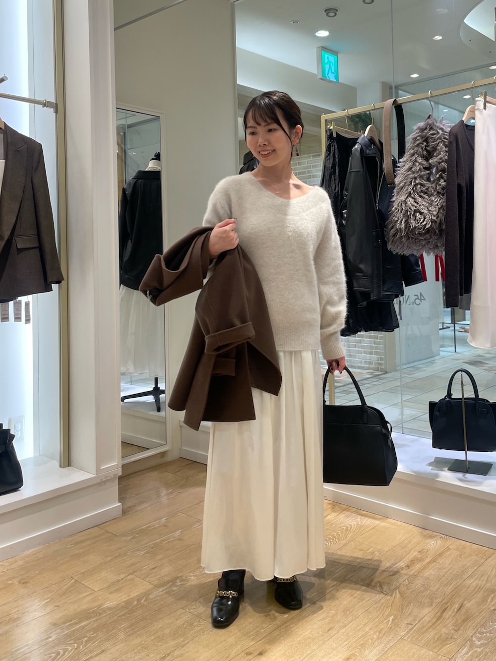 ベージュ系のニット/セーター、ブラウン系のその他アウター、ブラック系のショルダーバッグを着用したレディースの秋コーディネートの5枚目の写真