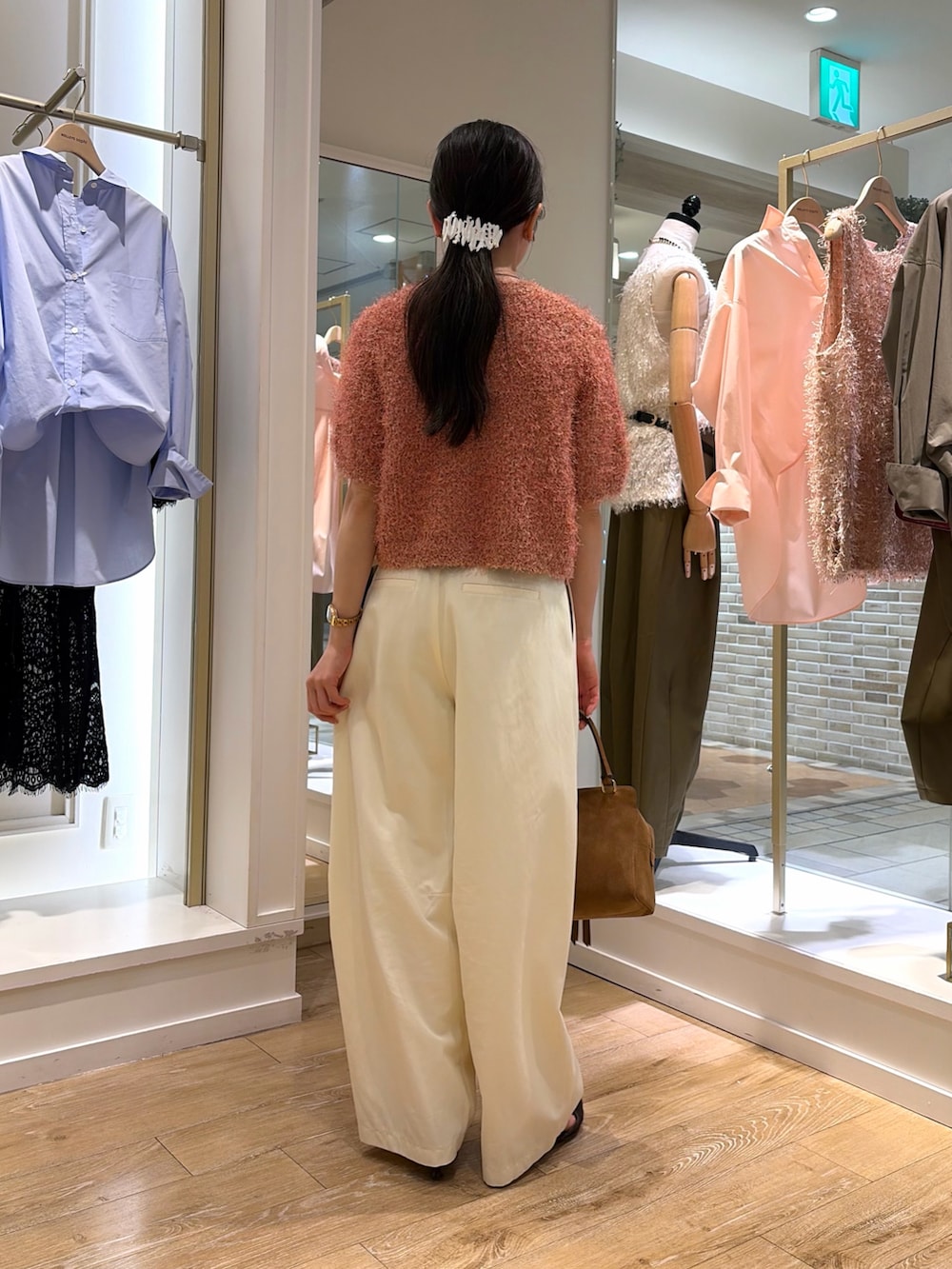ピンク系のニット/セーター、ホワイト系のチノパンツ、イエロー系のショルダーバッグを着用したレディースの秋コーディネートの4枚目の写真