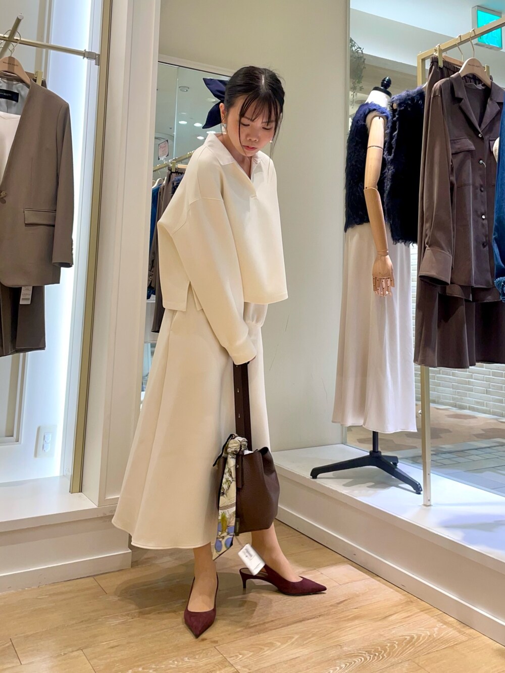 ブラウン系のショルダーバッグ、グリーン系のネクタイ、ホワイト系のTシャツ/カットソーを着用したレディースの秋コーディネートの4枚目の写真