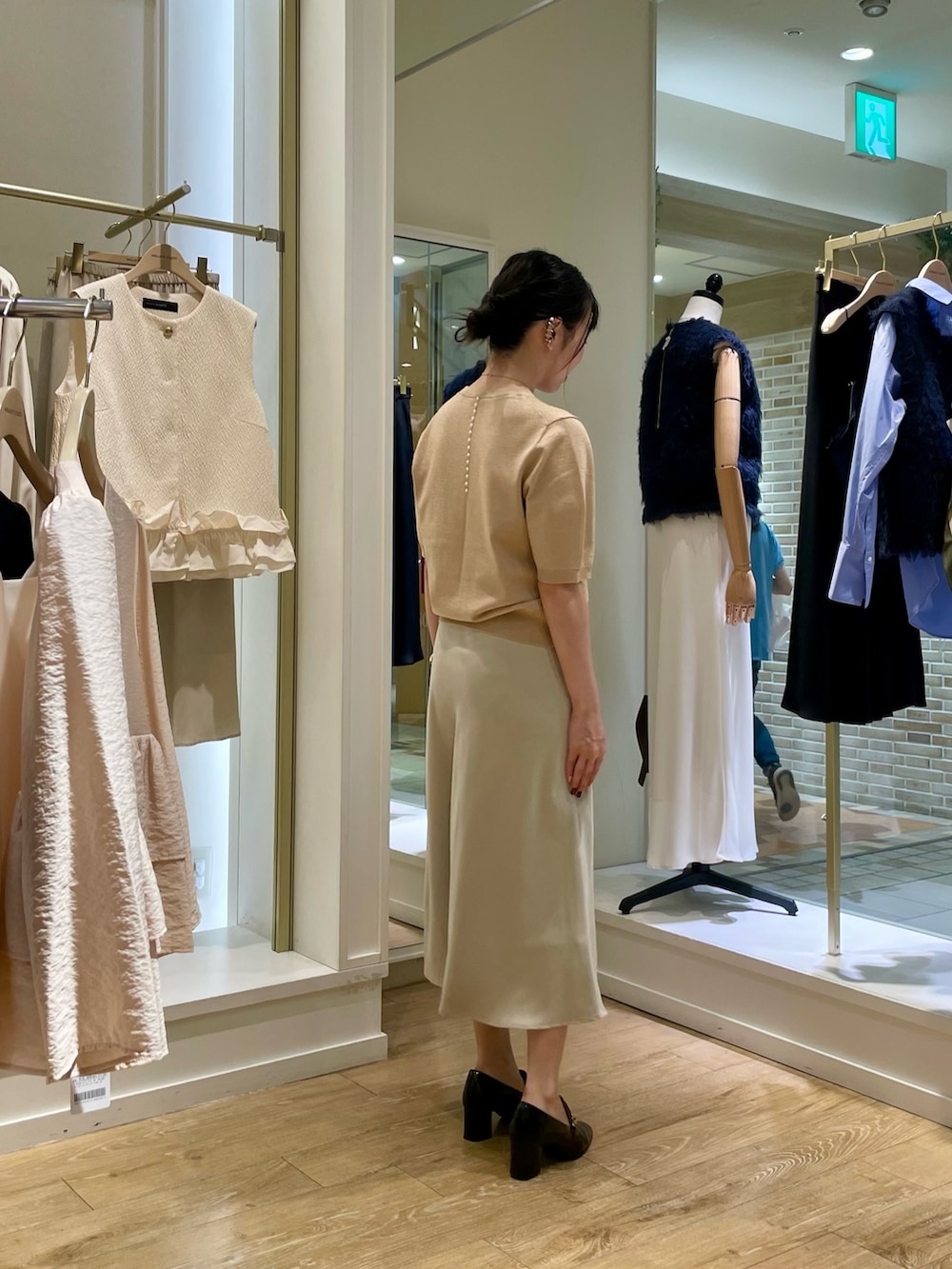 イエロー系のニット/セーター、ベージュ系のスカートを着用したレディースの秋コーディネートの6枚目の写真