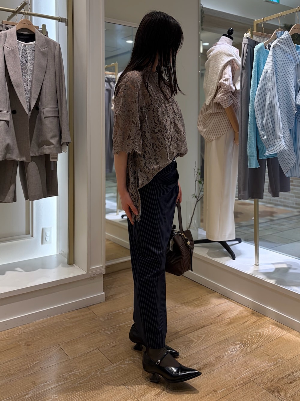 ブルー系のスカート、ブラウン系のショルダーバッグ、その他のネックレスを着用したレディースの冬コーディネートの5枚目の写真