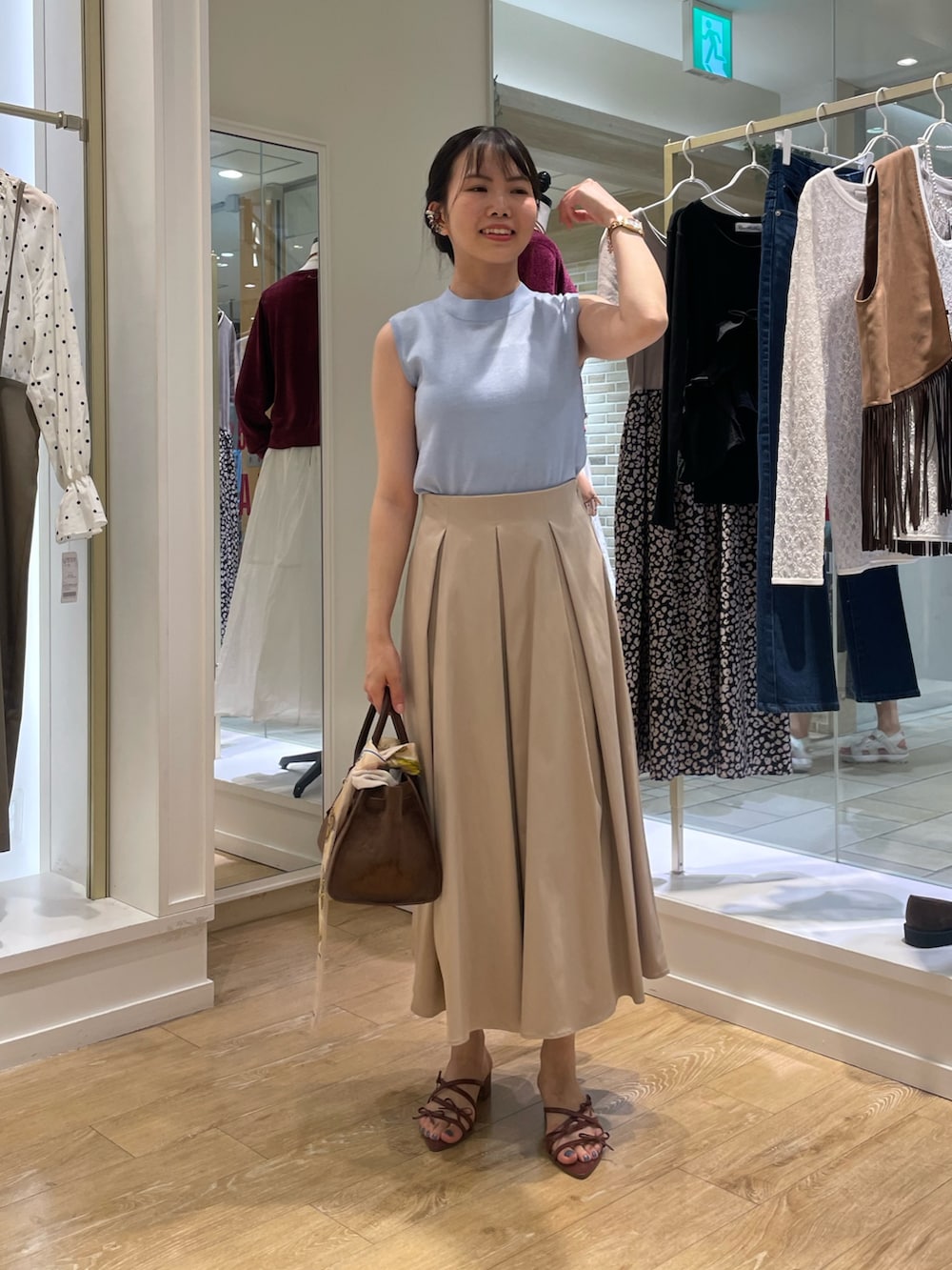 ブルー系のニット/セーター、ベージュ系のスカートを着用したレディースの秋コーディネートの2枚目の写真