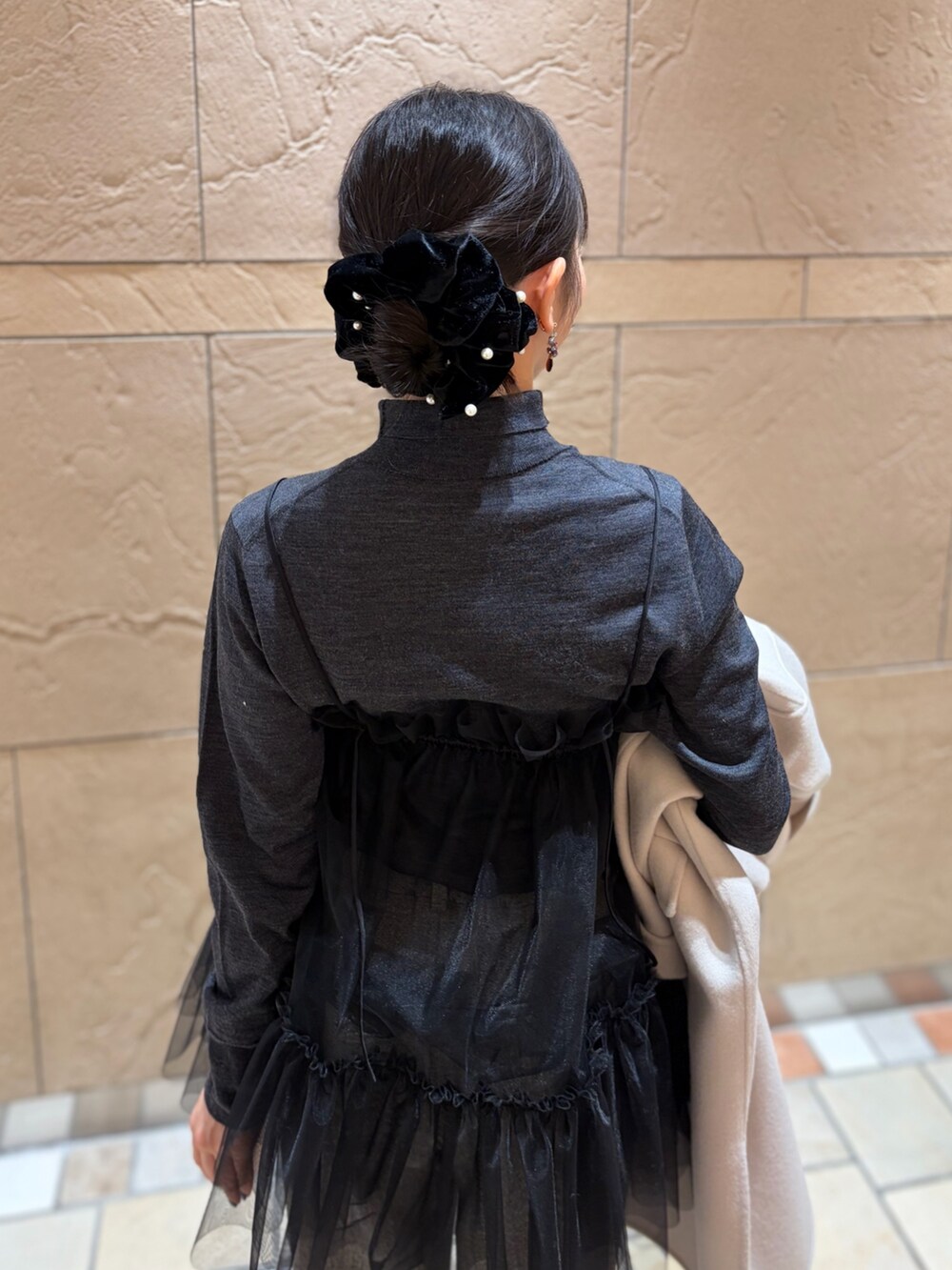 ベージュ系のステンカラーコート、グレー系のニット/セーター、ブラック系のキャミソールを着用したレディースの冬コーディネートの10枚目の写真