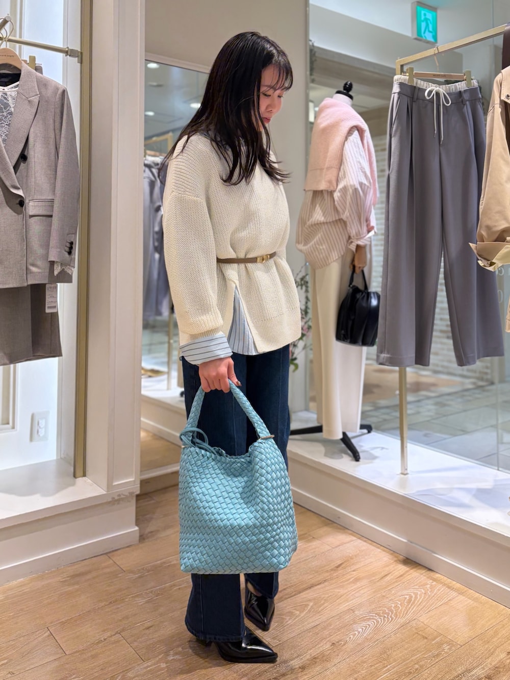 ブルー系のシャツ/ブラウス、ホワイト系のニット/セーター、ブルー系のショルダーバッグを着用したレディースの冬コーディネートの4枚目の写真