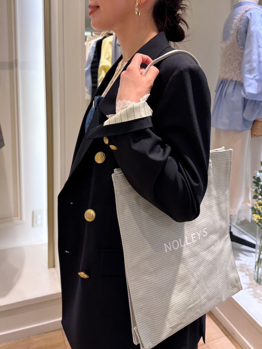 グレー系のトートバッグ、ブルー系のテーラードジャケット、ブルー系のキャミソールを着用したレディースの冬コーディネートの7枚目の写真