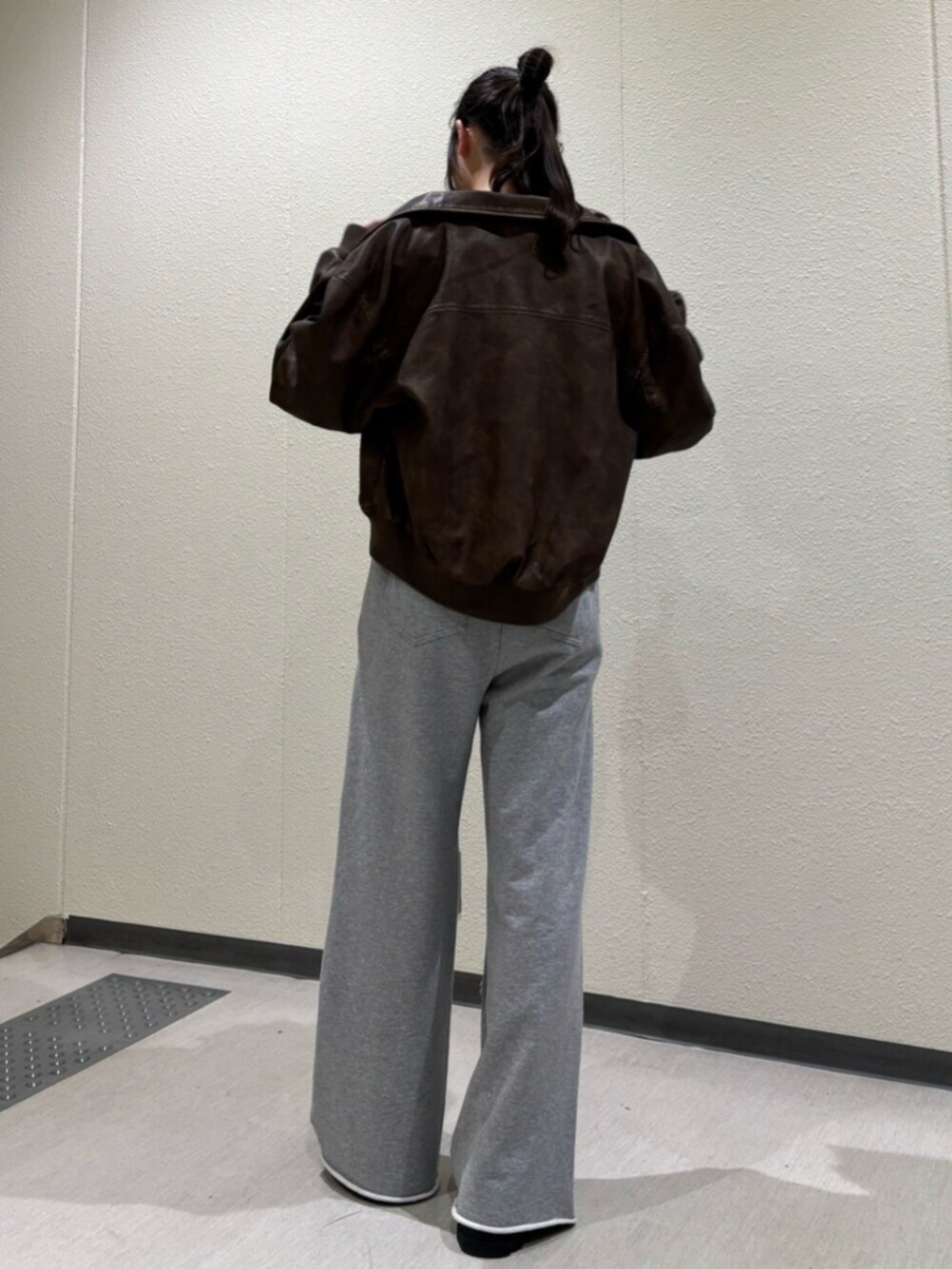 ブラック系のブーツ、ブラウン系のブルゾン、ブラック系のTシャツ/カットソーを着用したレディースの秋コーディネートの3枚目の写真