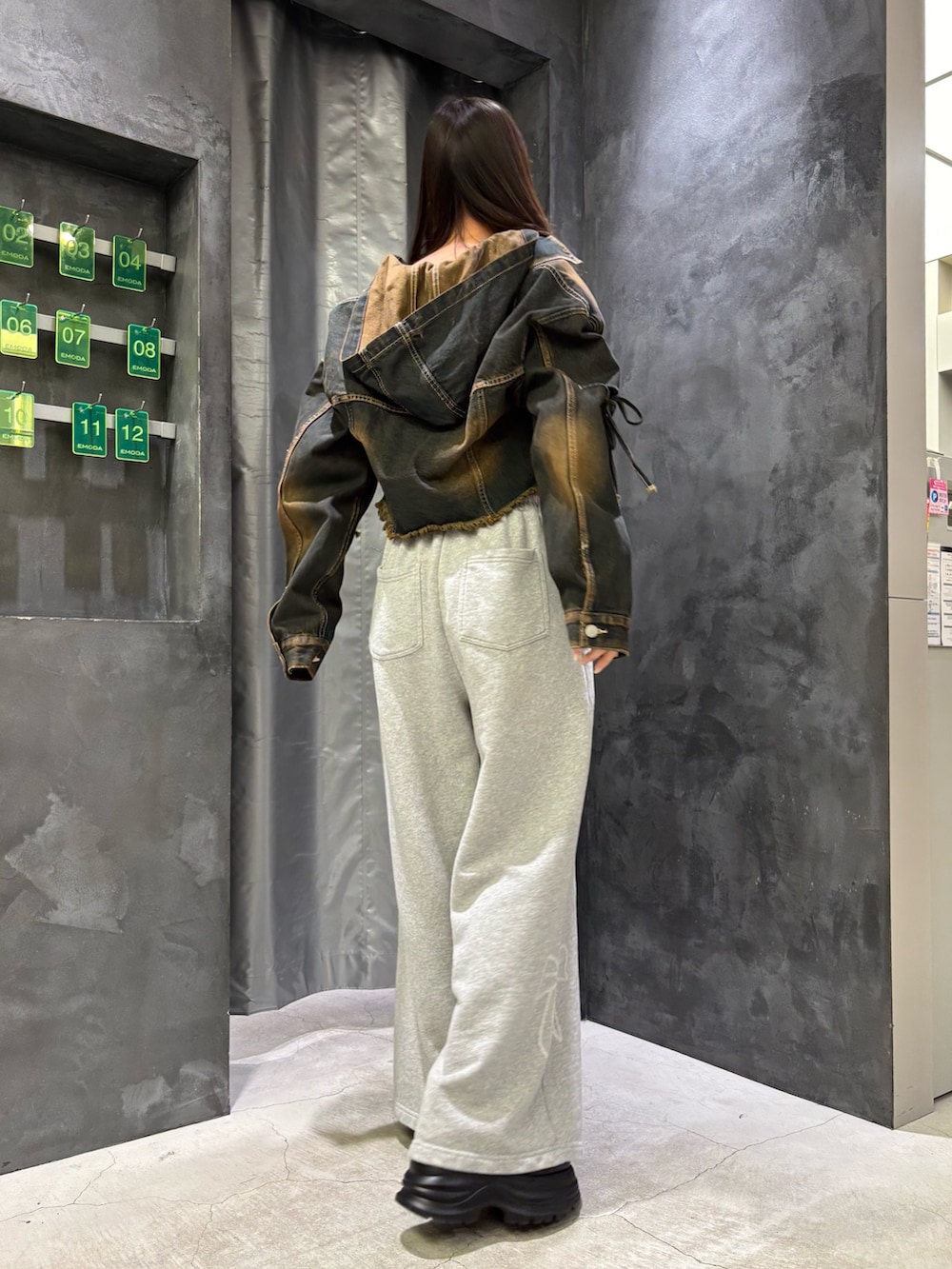 ブルー系のデニムジャケット、ブラック系のニット/セーター、グレー系のスウェットパンツを着用したレディースの冬コーディネートの3枚目の写真