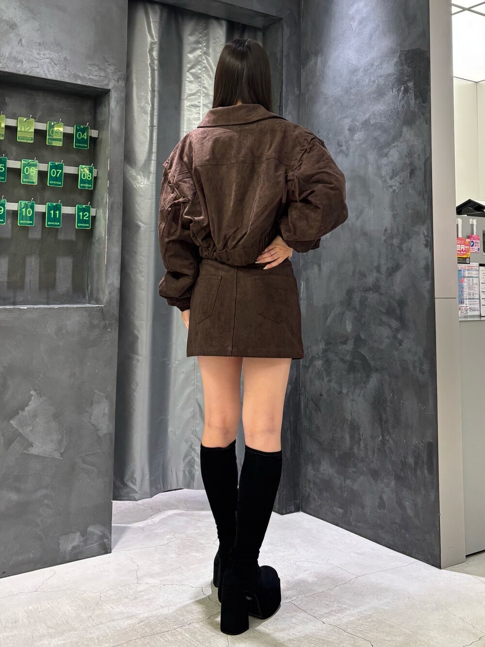 ブラウン系のブルゾン、グレー系のニット/セーター、ブラウン系のスカートを着用したレディースの秋コーディネートの3枚目の写真