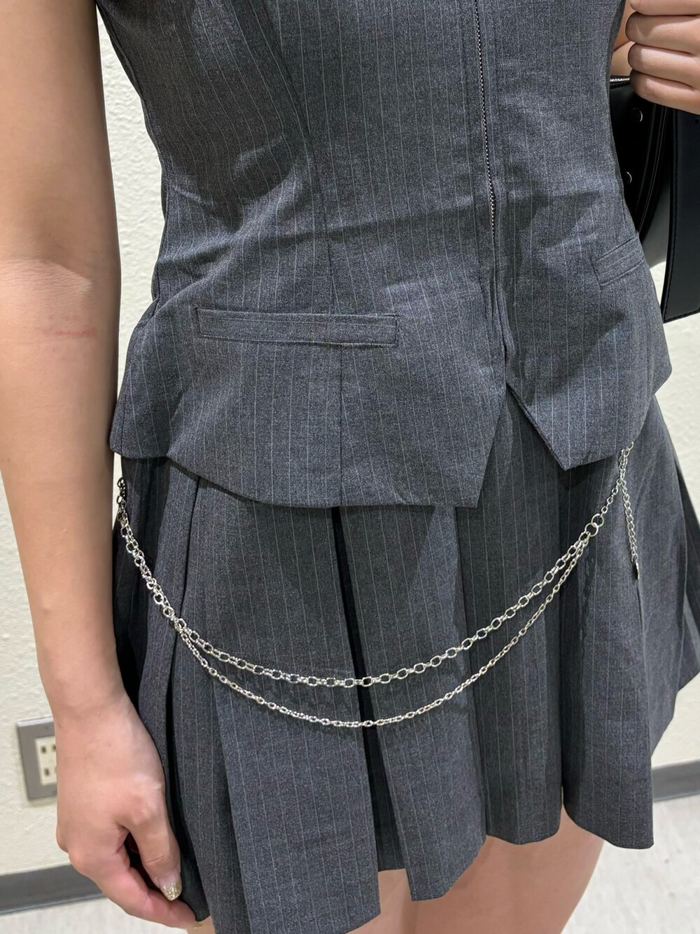 ブラック系のサンダル、ブラック系のハンドバッグ、グレー系のワンピースを着用したレディースの春コーディネートの4枚目の写真