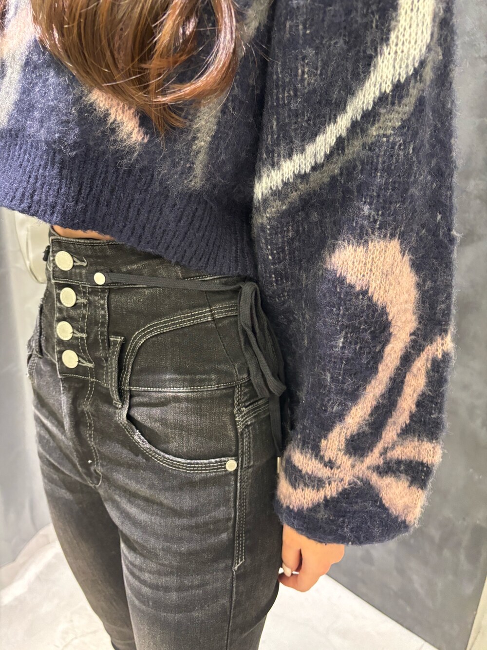 ブルー系のニット/セーター、グレー系のハンドバッグ、ブラック系のデニムパンツを着用したレディースの秋コーディネートの4枚目の写真