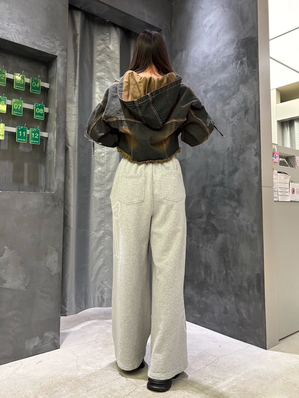 ブルー系のデニムジャケット、ブラック系のニット/セーター、グレー系のスウェットパンツを着用したレディースの冬コーディネートの4枚目の写真