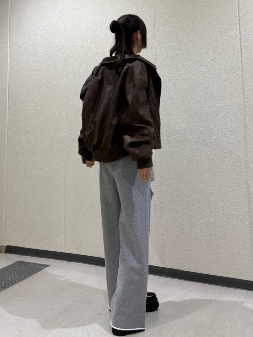 ブラック系のブーツ、ブラウン系のブルゾン、ブラック系のTシャツ/カットソーを着用したレディースの秋コーディネートの4枚目の写真