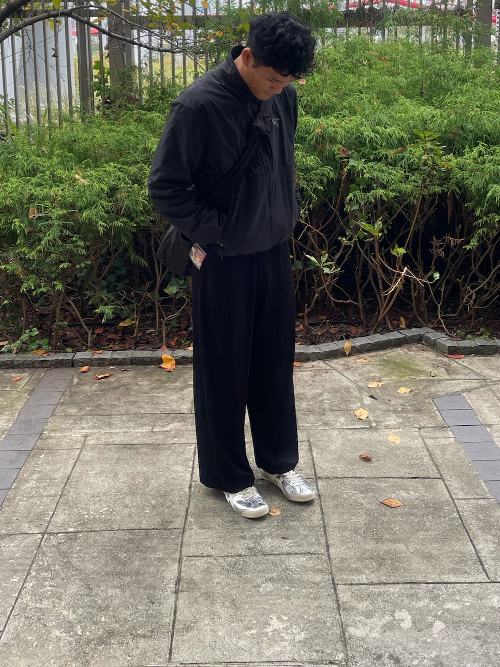 ブラック系のその他パンツ、ホワイト系のスニーカー、ブラック系のジャケット/アウターを着用したメンズの秋コーディネートの2枚目の写真