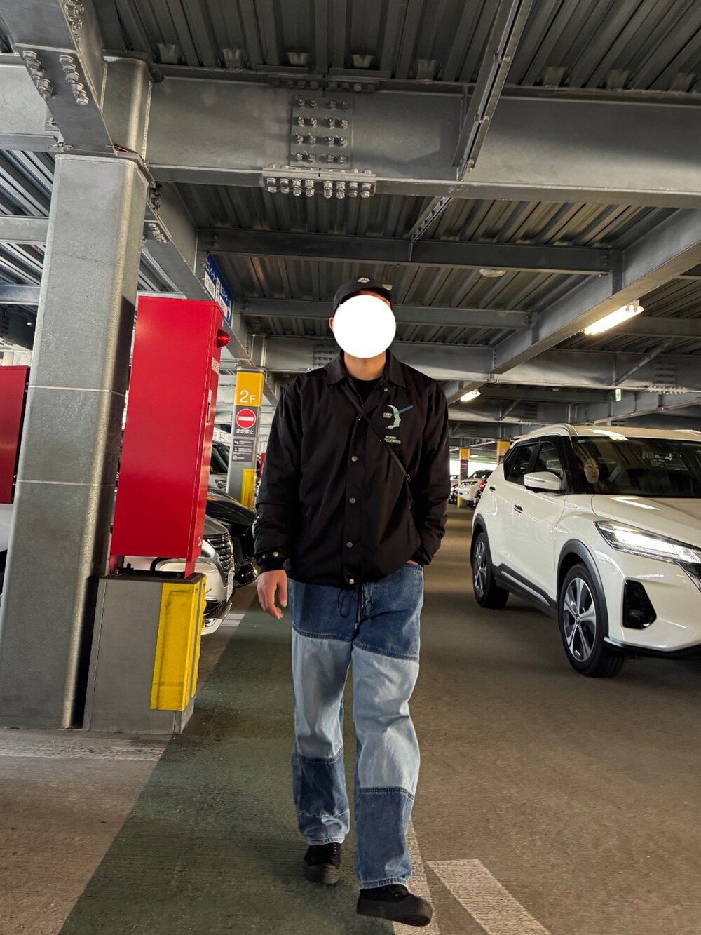 ブルー系のデニムパンツ、ブラック系のスニーカー、ブラック系のジャケット/アウターを着用したメンズの冬コーディネートの2枚目の写真