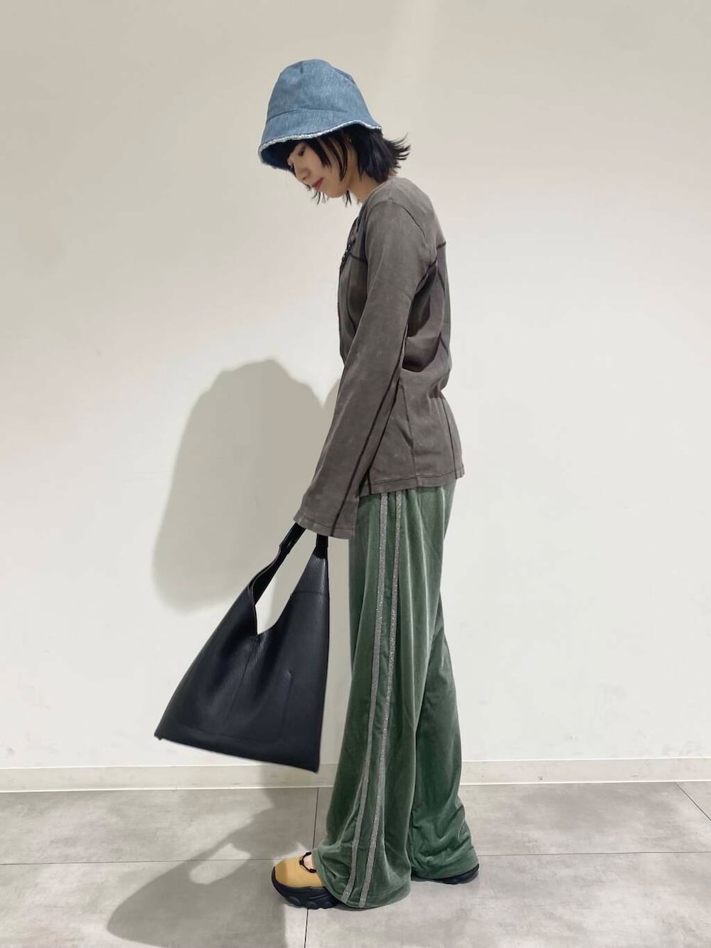 ブラック系のトートバッグ、ベージュ系のスニーカー、ホワイト系のTシャツ/カットソーを着用したレディースの夏コーディネートの2枚目の写真