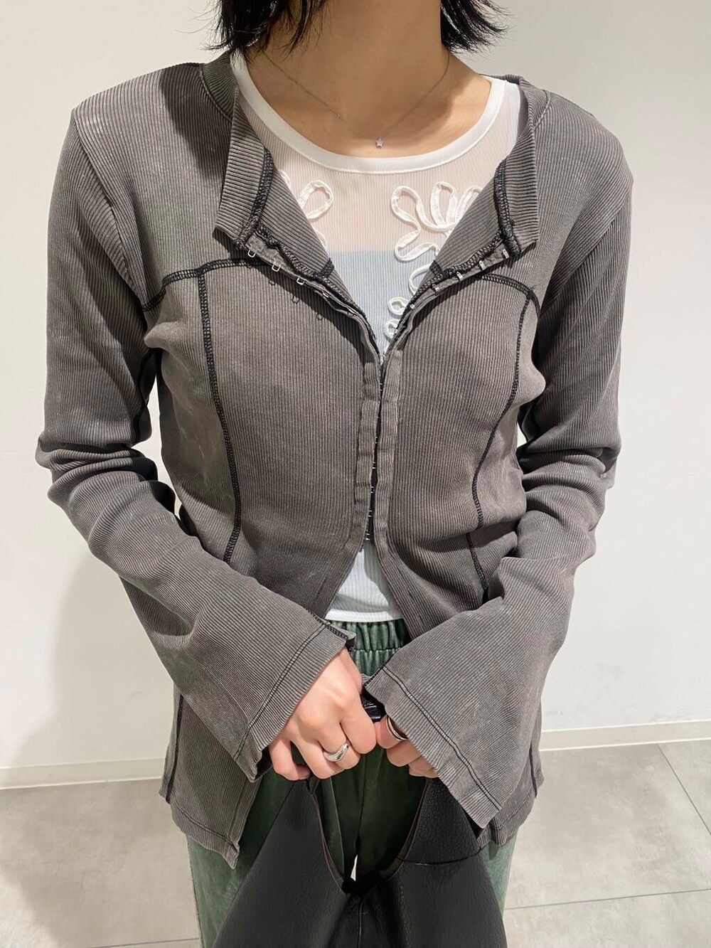 ブラック系のトートバッグ、ベージュ系のスニーカー、ホワイト系のTシャツ/カットソーを着用したレディースの夏コーディネートの3枚目の写真