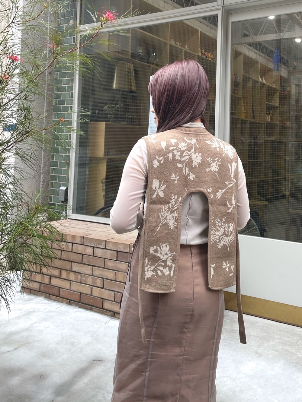 ベージュ系のベスト、ベージュ系のスカート、ブラック系のブーツを着用したレディースの春コーディネートの4枚目の写真