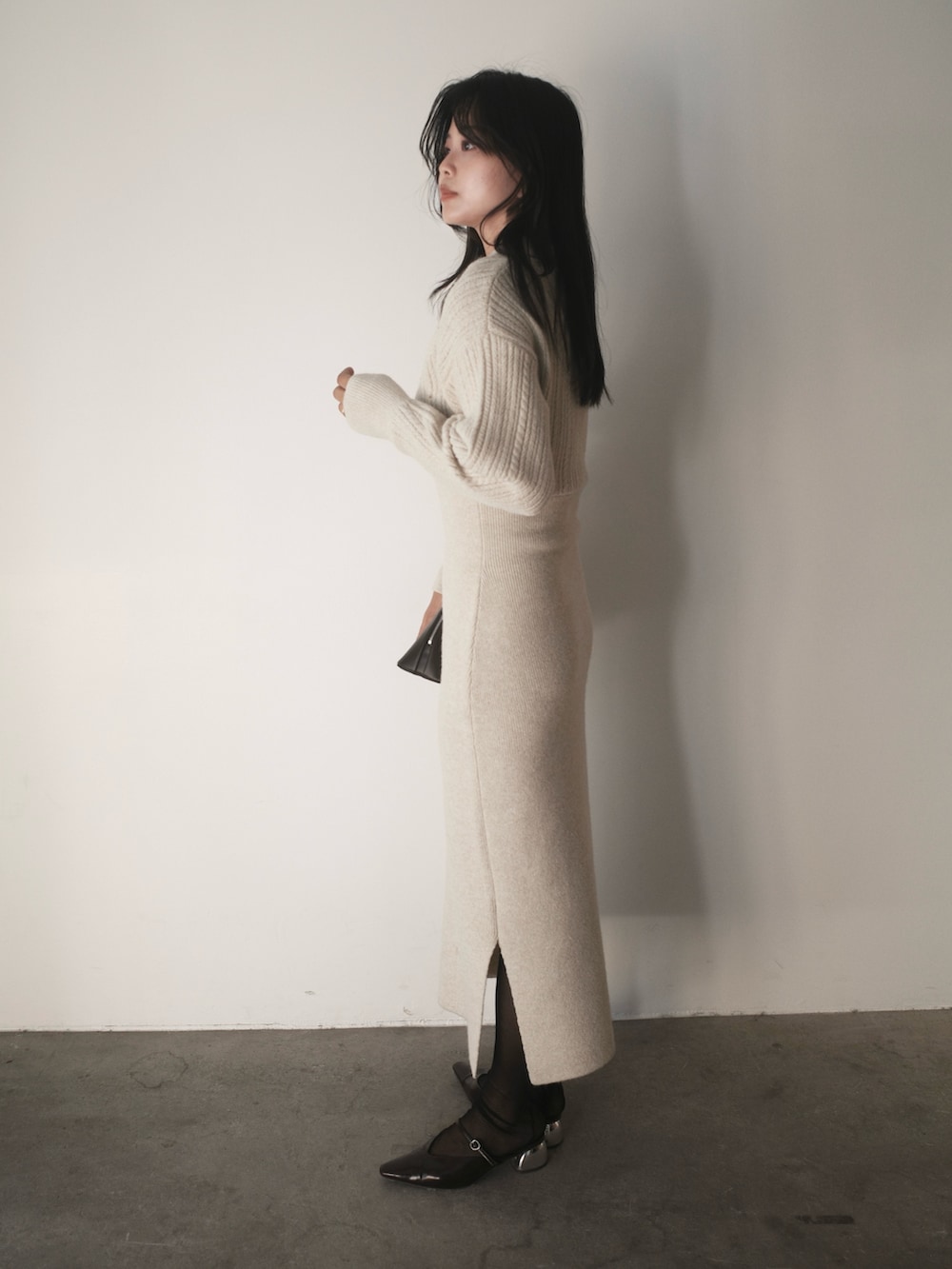 ベージュ系のワンピース、ブラウン系のボストンバッグ、ブラウン系のパンプスを着用したレディースの秋コーディネートの2枚目の写真