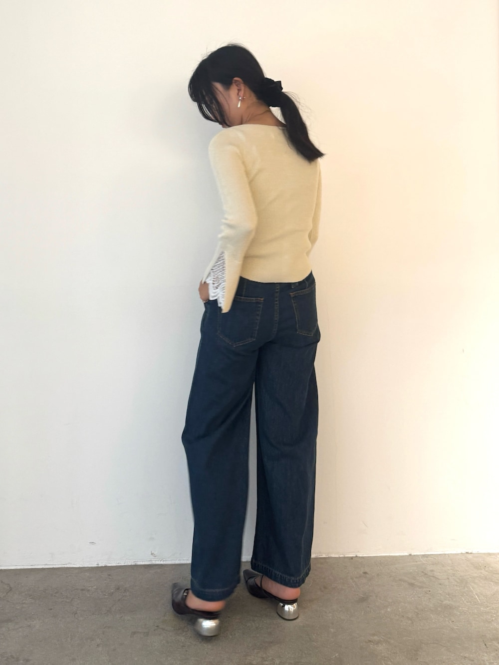 ホワイト系のニット/セーター、ブルー系のデニムパンツ、ブラウン系のパンプスを着用したレディースの秋コーディネートの5枚目の写真