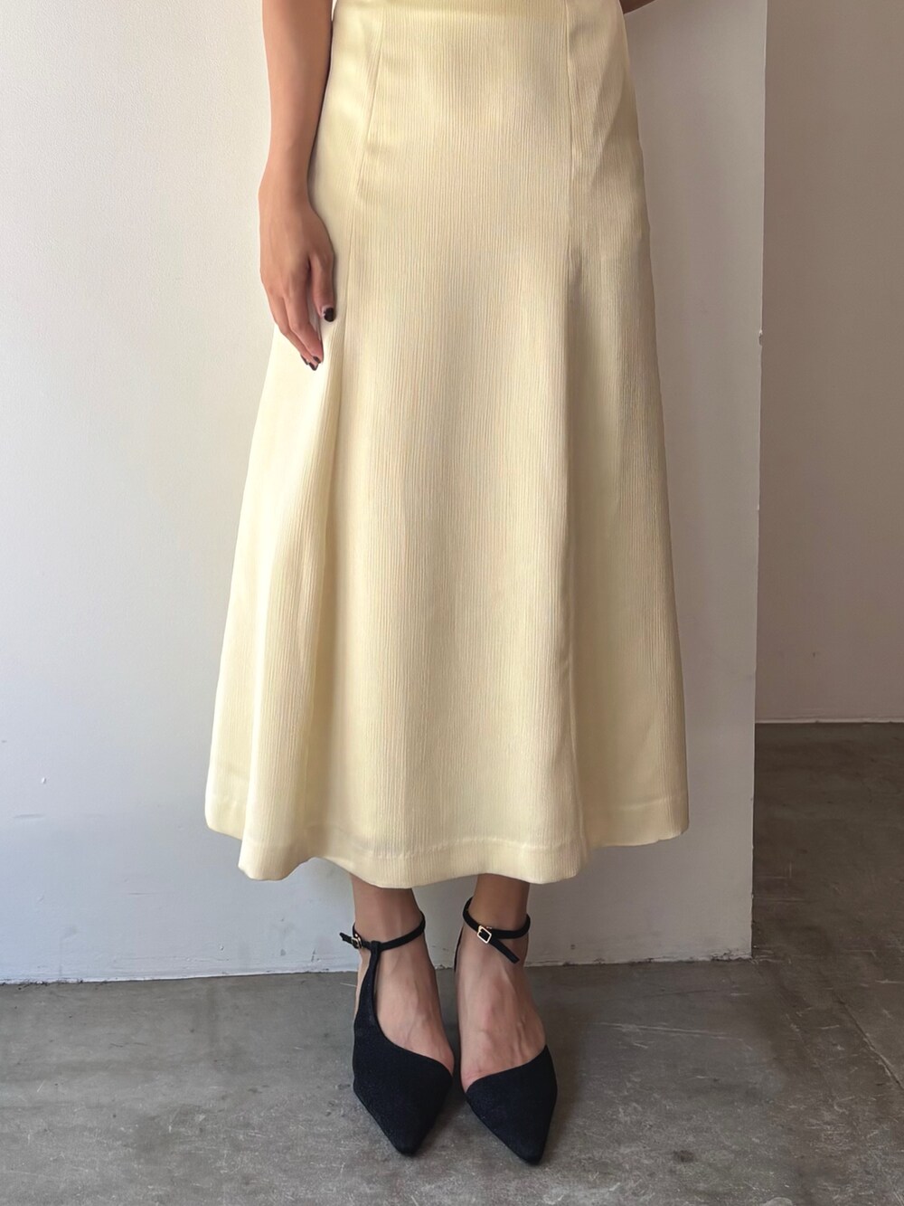 イエロー系のドレス、ブラック系のパンプスを着用したレディースの夏コーディネートの7枚目の写真