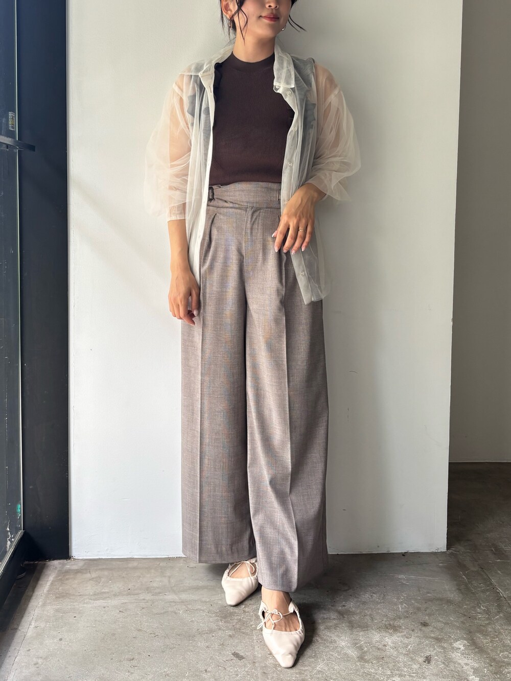 ブラウン系のニット/セーター、ベージュ系のその他パンツ、ホワイト系のサンダルを着用したレディースの春コーディネートの2枚目の写真