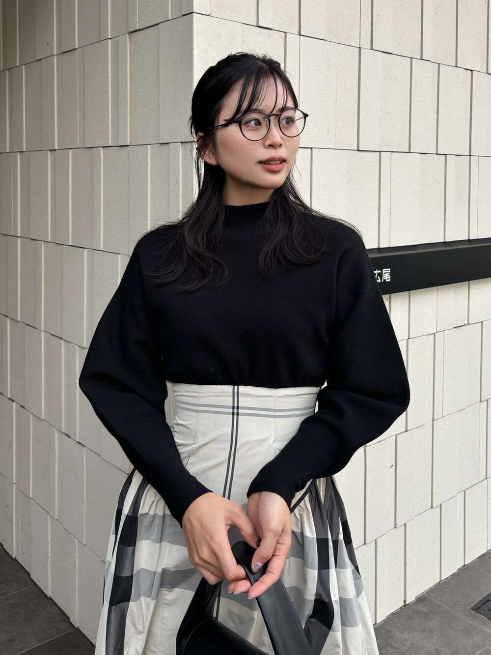 ホワイト系のワンピース、ブラック系のハンドバッグ、ブラック系のブーツを着用したレディースの冬コーディネートの4枚目の写真