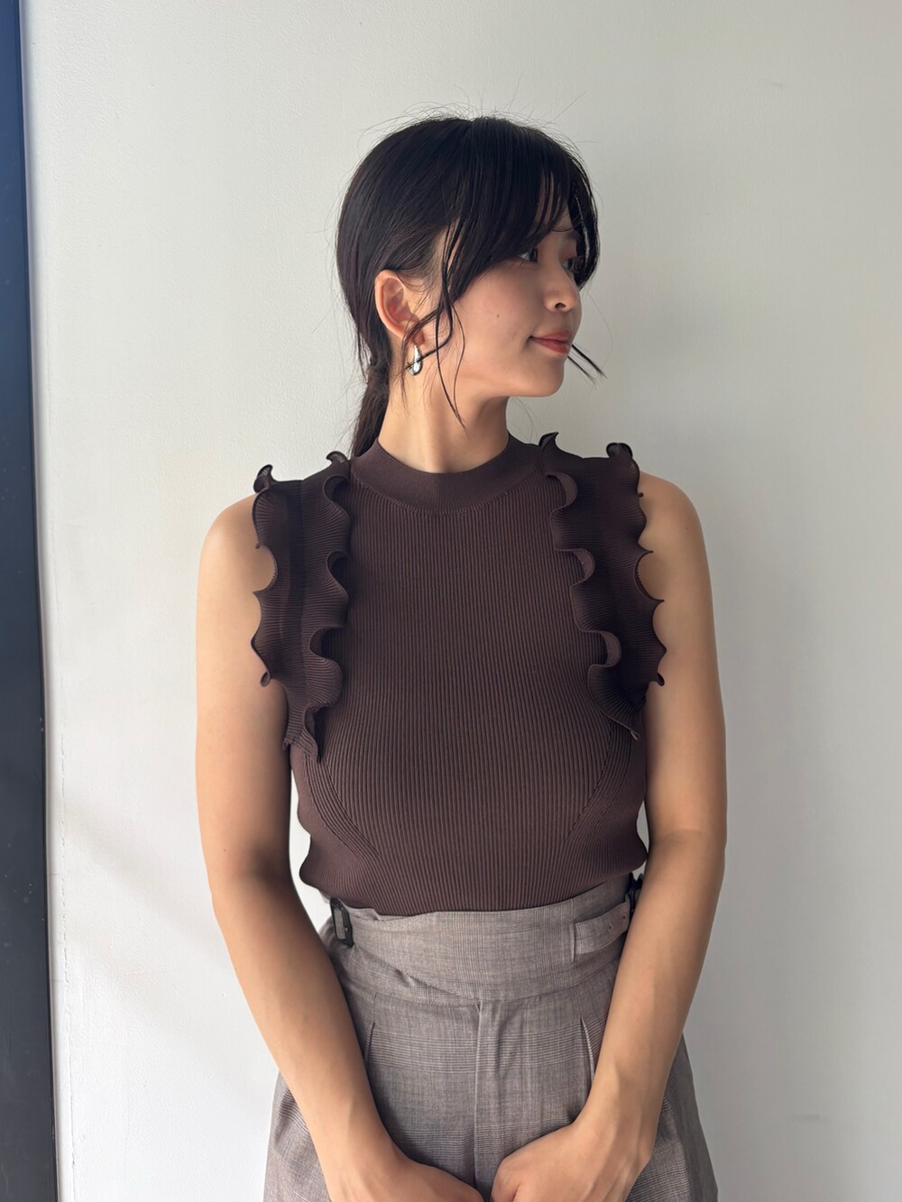 ブラウン系のニット/セーター、ベージュ系のその他パンツ、ホワイト系のサンダルを着用したレディースの春コーディネートの4枚目の写真