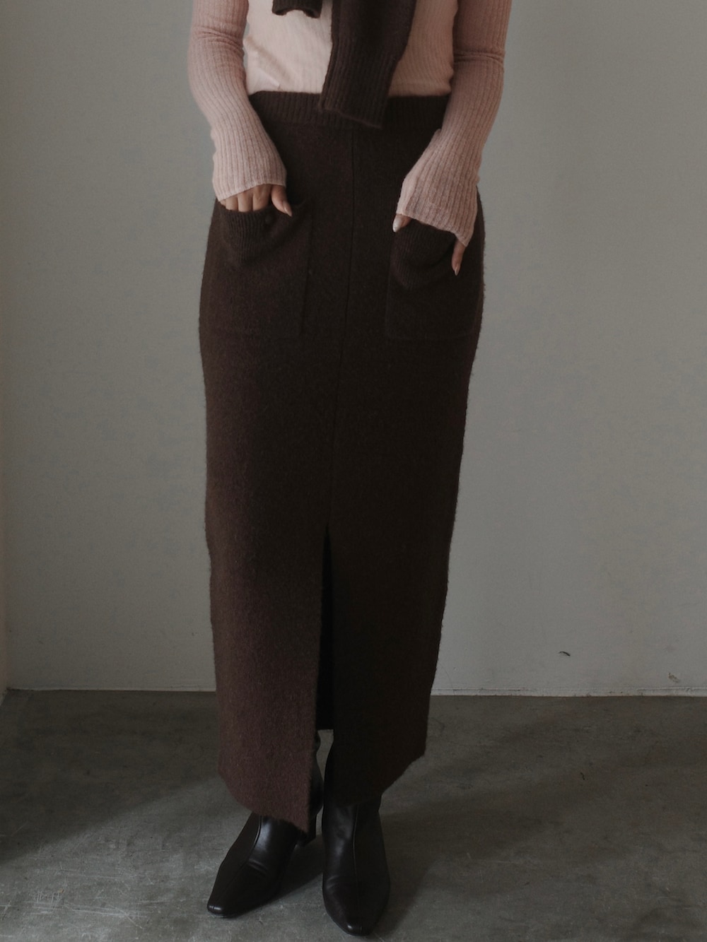 ピンク系のニット/セーター、ブラウン系のワンピース、ブラウン系のブーツを着用したレディースの秋コーディネートの6枚目の写真