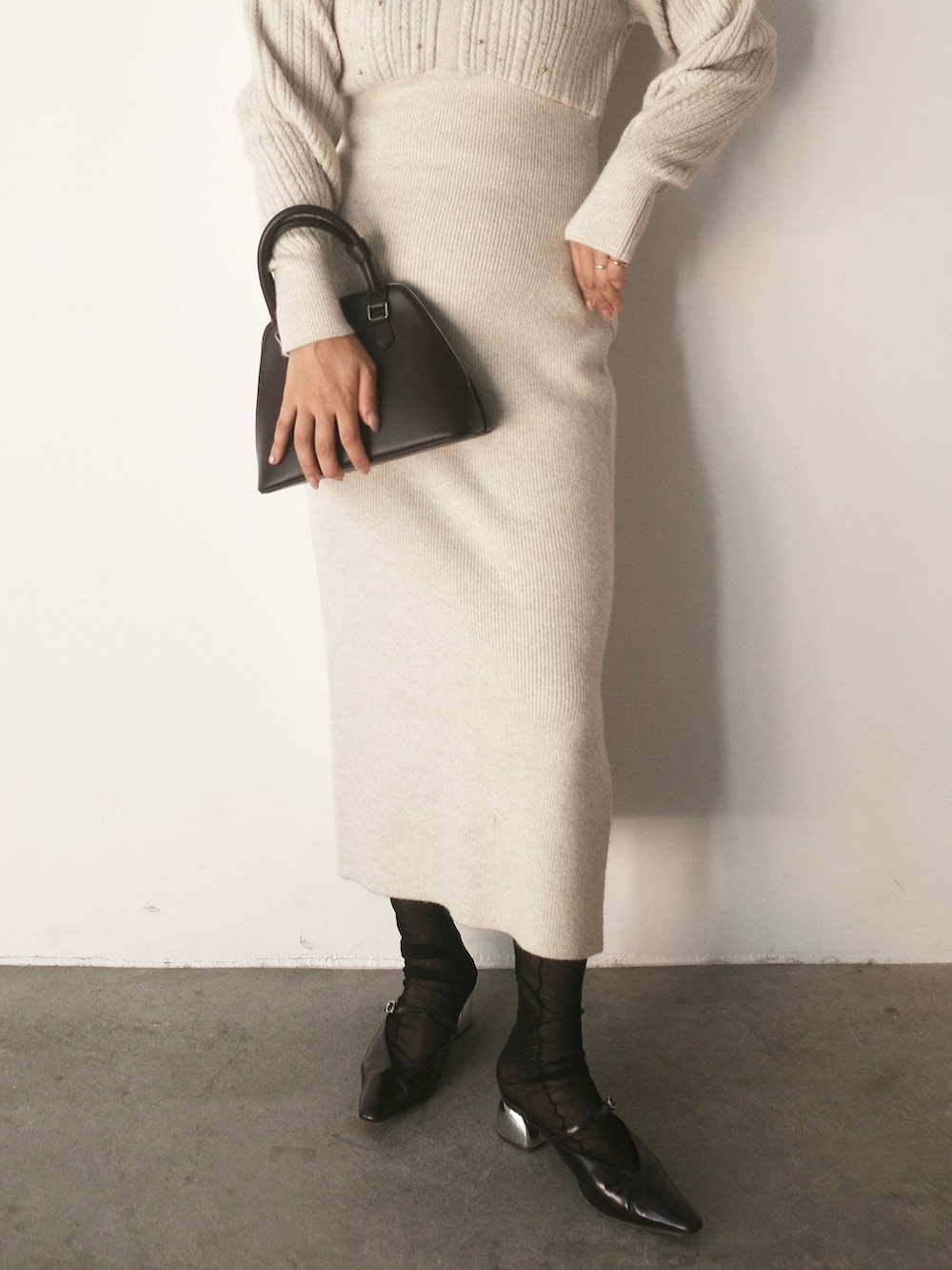 ベージュ系のワンピース、ブラウン系のボストンバッグ、ブラウン系のパンプスを着用したレディースの秋コーディネートの7枚目の写真