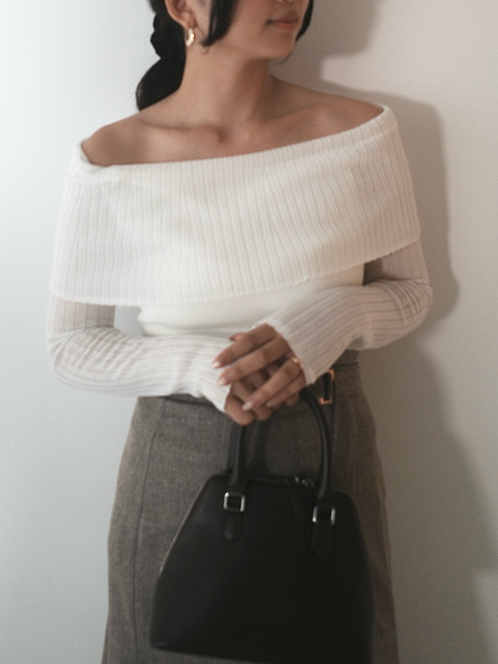 ホワイト系のニット/セーター、ブラウン系のスカート、ブラウン系のボストンバッグを着用したレディースの秋コーディネートの4枚目の写真