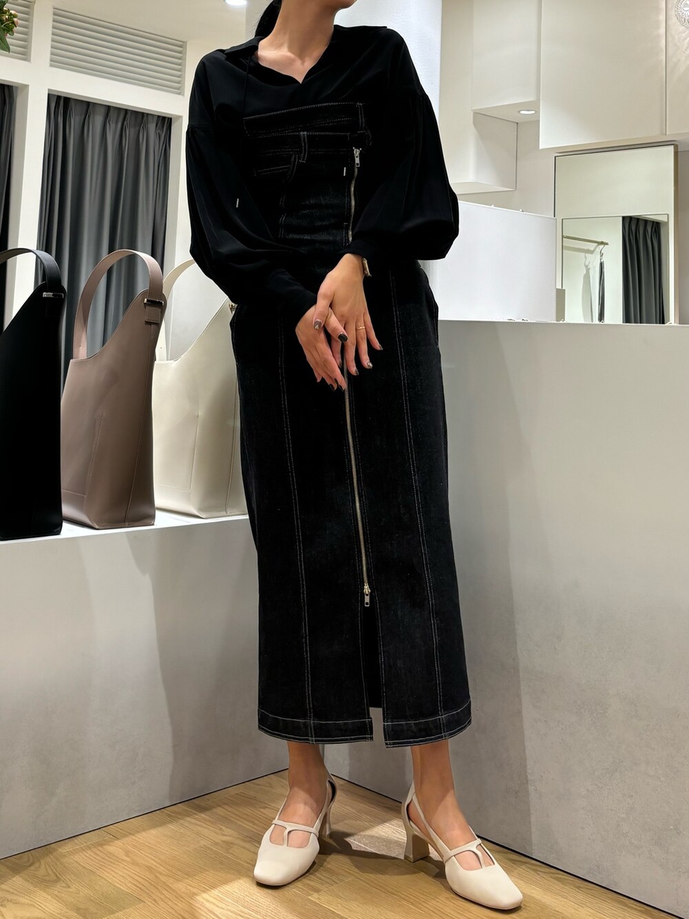 ブラック系のワンピース、ホワイト系のパンプス、ブラック系のシャツ/ブラウスを着用したレディースの春コーディネートの3枚目の写真