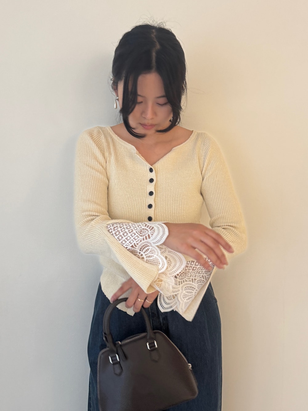 ホワイト系のニット/セーター、ブルー系のデニムパンツ、ブラウン系のパンプスを着用したレディースの秋コーディネートの2枚目の写真