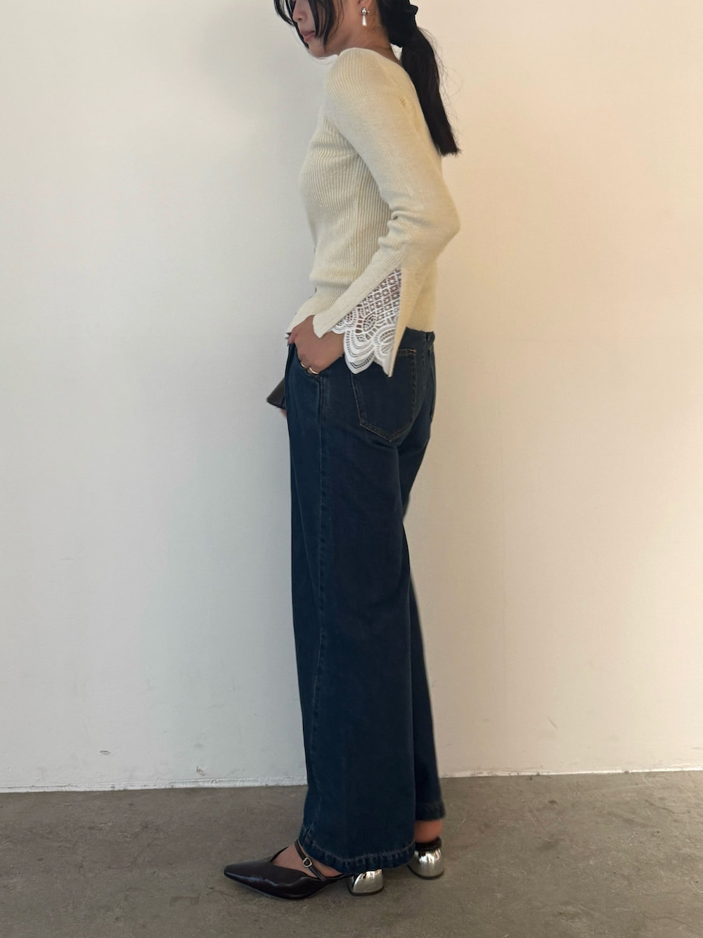 ホワイト系のニット/セーター、ブルー系のデニムパンツ、ブラウン系のパンプスを着用したレディースの秋コーディネートの4枚目の写真