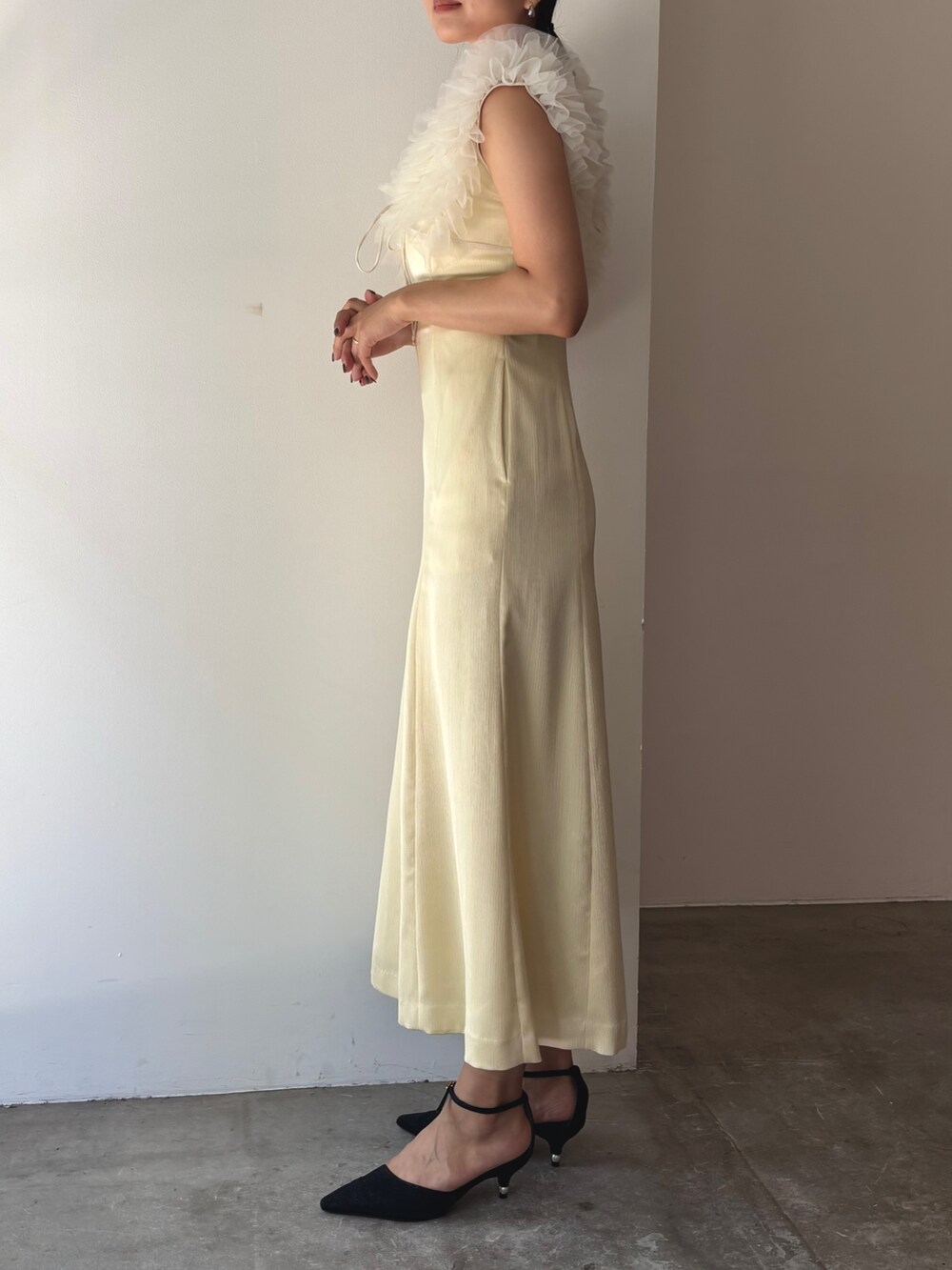 イエロー系のドレス、ブラック系のパンプスを着用したレディースの夏コーディネートの3枚目の写真