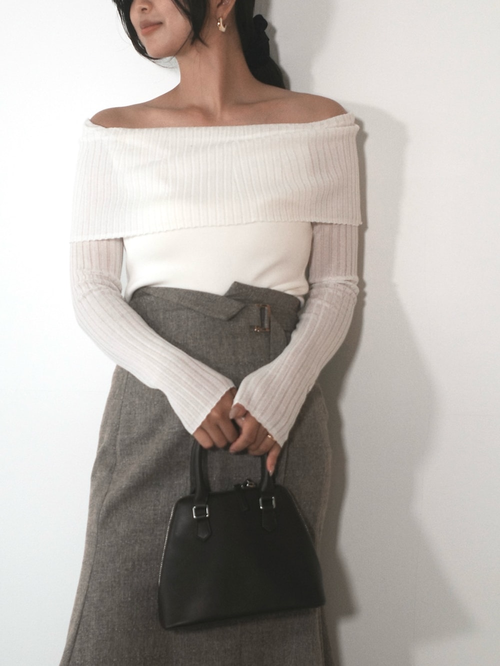 ホワイト系のニット/セーター、ブラウン系のスカート、ブラウン系のボストンバッグを着用したレディースの秋コーディネートの6枚目の写真