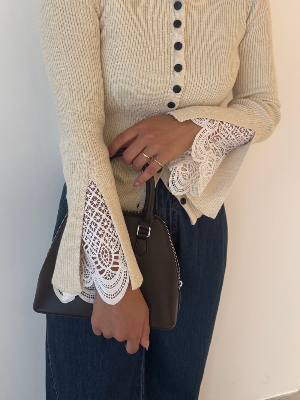 ホワイト系のニット/セーター、ブルー系のデニムパンツ、ブラウン系のパンプスを着用したレディースの秋コーディネートの3枚目の写真